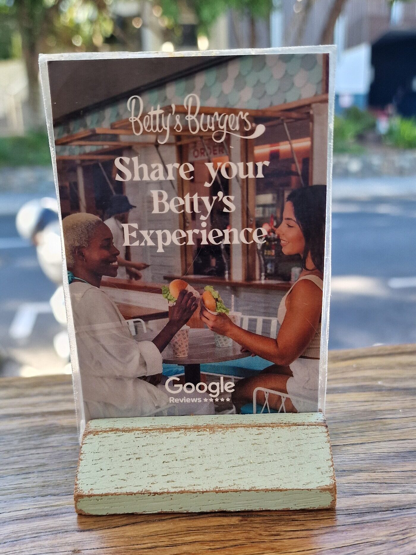 Tischaufsteller einer Burger-Kette: professionell gestaltete Karte mit Google-Logo, aber ohne QR-Code oder Bewertungslink