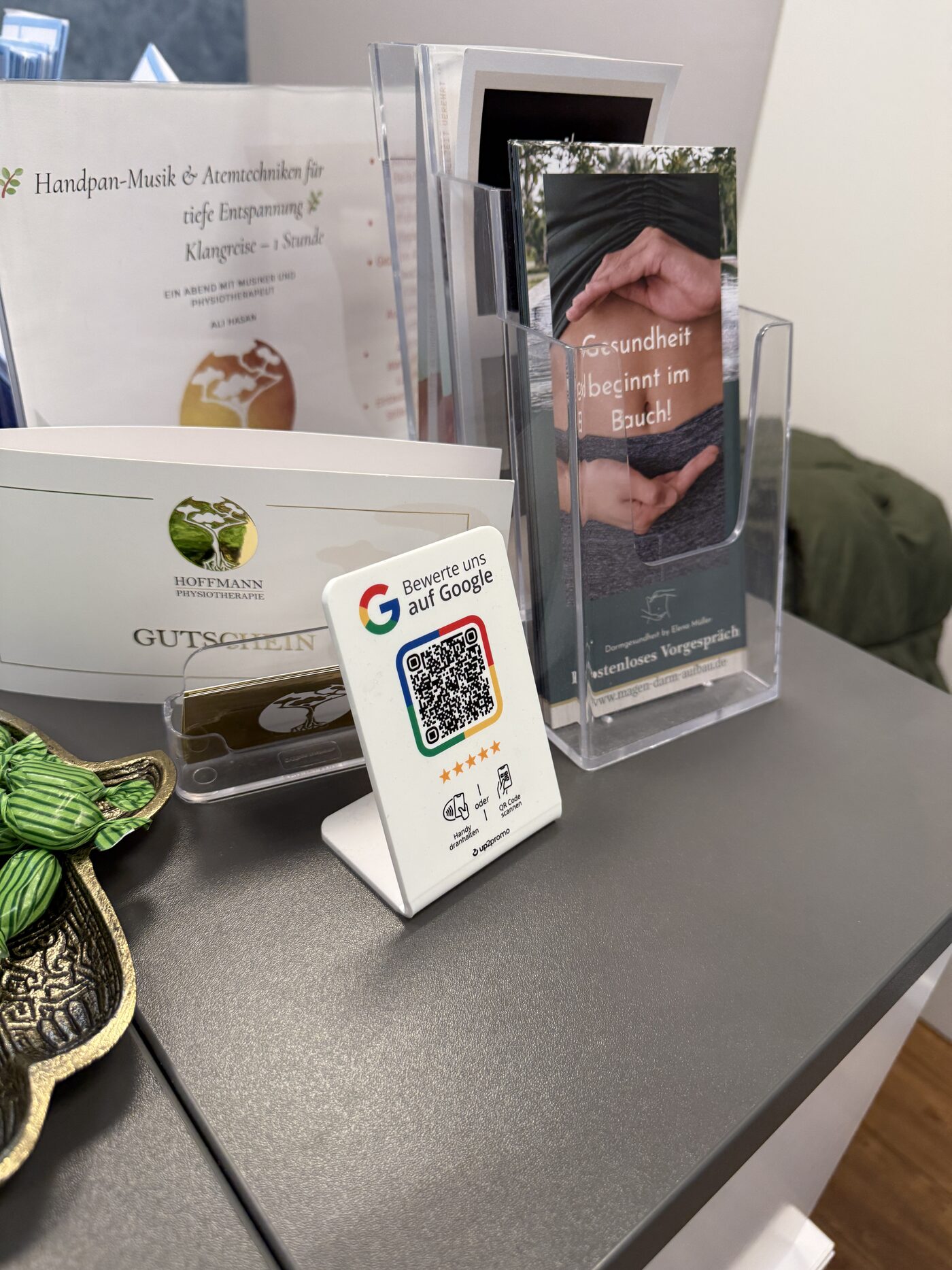 NFC-Aufsteller einer Physiotherapie-Praxis: „Bewerte uns auf Google – Handy dranhalten oder QR-Code scannen“